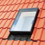 Fereastră de acces VELUX GVK montată pe acoperiș din țiglă ceramică