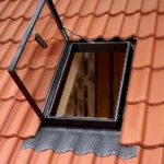 Fereastră de acces pe acoperiș VELUX GVT deschisă, montată pe acoperiș cu țiglă ceramică