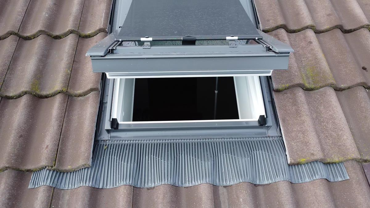Fereastră VELUX deschisă, cu racordul exterior și șorțul inferior pe țigla de beton